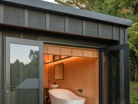 A bathroom with a bathtub and washbasin at Lakefront Luxury at Okere Falls Lake Rotoiti