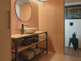 A bathroom with a wash basin and towels at Lakefront Luxury at Okere Falls Lake Rotoiti