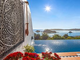 An outdoor area with an infinity pool and sea view at Paihia Holiday Home, Paihia