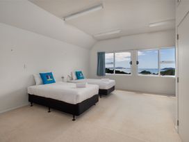 A bedroom with two beds and windows at Seabreeze Sanctuary - Paihia