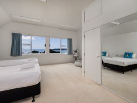 A bedroom with two beds and a view of the sea at Seabreeze Sanctuary - Paihia