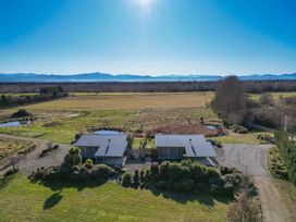 An aerial view of two houses surrounded by fields and trees at Tussock Cottage - Canterbury Holiday Home Canterbury