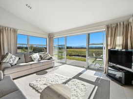 A living room with a sofa and a television at Tussock Cottage - Canterbury