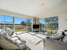 A living room with a sofa and television at Tussock Cottage - Canterbury