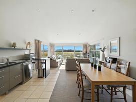 A living room featuring a kitchen, dining table and couches at Tussock Cottage - Canterbury Holiday Home Canterbury