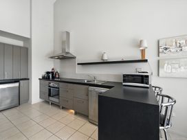 A kitchen with appliances and bar stools at Tussock Cottage - Canterbury Holiday Home