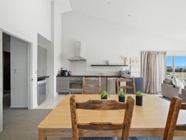 A kitchen with dining table and chairs at Tussock Cottage - Canterbury