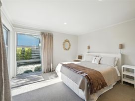 A bedroom with a bed and a window at Tussock Cottage - Canterbury Holiday Home in Canterbury