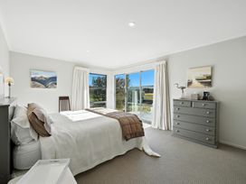 A bedroom with a bed and sliding door at Tussock Cottage - Canterbury Holiday Home, Canterbury