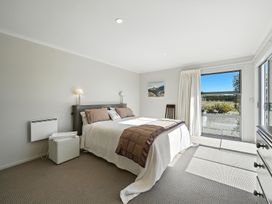 A bedroom with a bed and window at Tussock Cottage - Canterbury Holiday Home in Canterbury