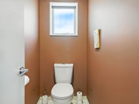 A bathroom with a toilet and a window at Tussock Cottage - Canterbury Holiday Home Canterbury
