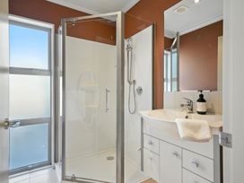 A bathroom with a shower and sink at Tussock Cottage - Canterbury Holiday Home Canterbury