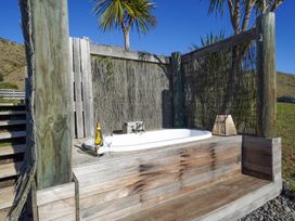 An outdoor bath area with a bathtub and wine at Tussock Cottage - Canterbury Holiday Home in Canterbury