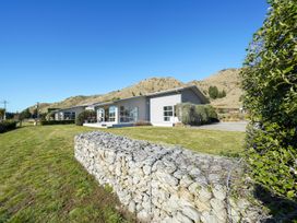 A house surrounded by grass and mountains at Tussock Cottage - Canterbury Holiday Home, Canterbury
