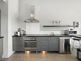 A kitchen with stove, sink, dishwasher, and microwave at Flax Cottage - Canterbury Holiday Home, Canterbury