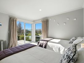 A bedroom with two beds and large windows at Flax Cottage - Canterbury Holiday Home Canterbury