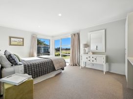 A bedroom with a bed and a dresser at Flax Cottage - Canterbury Holiday Home in Canterbury