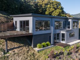 A house with a deck and large windows at Nelson Holiday home in Nelson