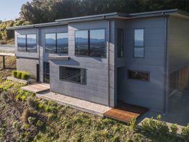 A house with large windows and a deck at Nelson Holiday home in Nelson