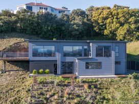 A house on a hill with a deck and garden at Nelson Holiday home in Nelson