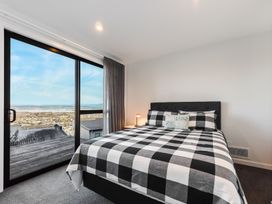 A bedroom with a bed and windows overlooking the view at Nelson Holiday home in Nelson