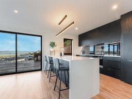 A kitchen with a large island and bar stools at Nelson Holiday home in Nelson