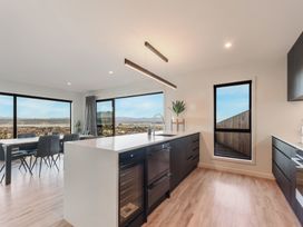 A kitchen with a kitchen island and dining area at Nelson Holiday home in Nelson