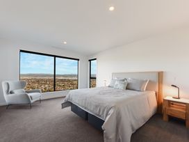A bedroom with a bed and windows at Nelson Holiday home in Nelson