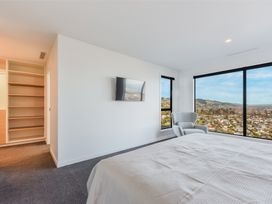 A bedroom with a bed and a tv mounted on the wall at Nelson Holiday home in Nelson
