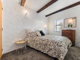 A bedroom with a bed and dresser at Sea Breeze - Orewa Oceanside Apartments, Orewa