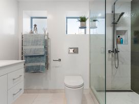 A bathroom with a shower and towel rack at Sea Breeze - Orewa Oceanside Apartments in Orewa