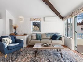 A living room with a sofa and armchair at Sea Breeze - Orewa Oceanside Apartments in Orewa