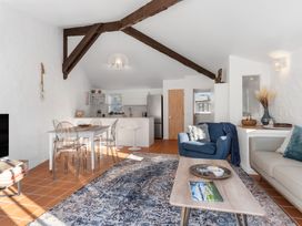 A living room with a sofa and dining area at Sea Breeze - Orewa Oceanside Apartments in Orewa