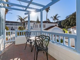 A balcony with two chairs and a table at Sea Breeze - Orewa Oceanside Apartments in Orewa