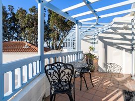 A balcony with a table and chairs at Sea Breeze - Orewa Oceanside Apartments in Orewa