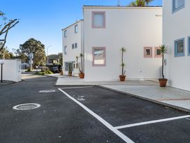 A building with parking space and plant pots at Sea Breeze - Orewa Oceanside Apartments in Orewa