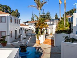 An outdoor area with a fountain and palm trees at Sea Breeze - Orewa Oceanside Apartments in Orewa