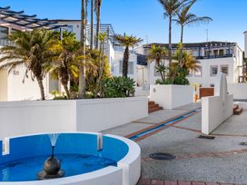 An outdoor area with a fountain and palm trees at Sea Breeze - Orewa Oceanside Apartments, Orewa