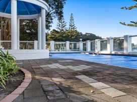 An outdoor area with a swimming pool covered with blue tarp at Sea Breeze - Orewa Oceanside Apartments, Orewa