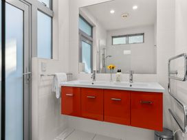 A bathroom with a sink and mirror at Mangawhai Heads