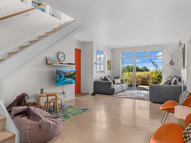 A living room with a television and seating area at Mangawhai Heads