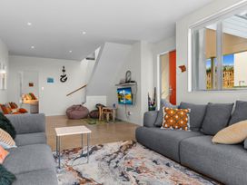 A living room with a sofa and television at Mangawhai Heads
