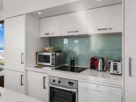 A kitchen with appliances including a microwave and coffee machine at Mangawhai Heads