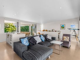 A living room with a kitchen and telescope at Mangawhai Heads