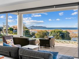A living room with a view of the beach at Mangawhai Heads