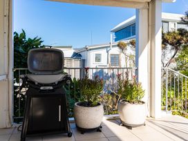 An outdoor area with a barbecue grill and planters at Mangawhai Heads