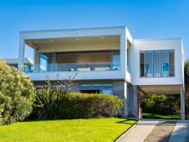 A house with large windows and a balcony at Mangawhai Heads, Mangawhai Heads