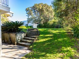 A garden with steps leading to grass and plants at Mangawhai Heads