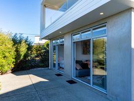 An outdoor area with glass doors and a patio at Mangawhai Heads