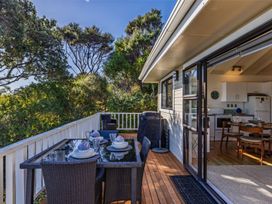 A deck with a table and chairs at Paua Shell - Coopers Beach Holiday Home Coopers Beach